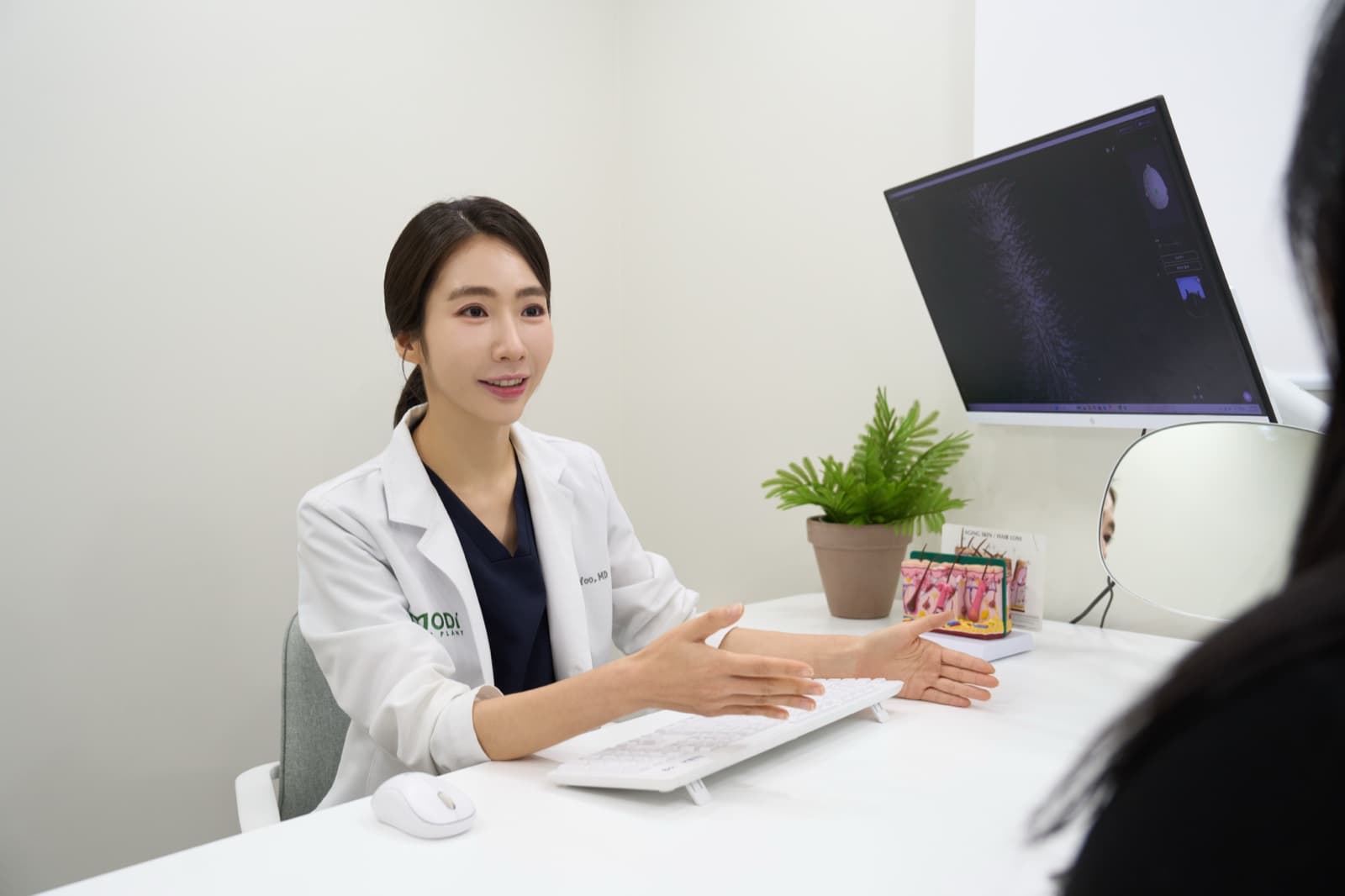 모디헤어플란트 의료진이 두피 분석 모니터를 보며 환자와 상담하는 모습